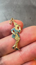 Load and play video in Gallery viewer, A 9 karat yellow gold charm pendant featuring an enamel depiction of Pinocchio in a blue, black, and white color scheme, with a yellow gold jump ring on top turned in hand
