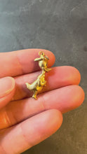 Load and play video in Gallery viewer, An 18 karat yellow gold charm pendant in the shape of a cartoon duck turned in the hand on a dark background
