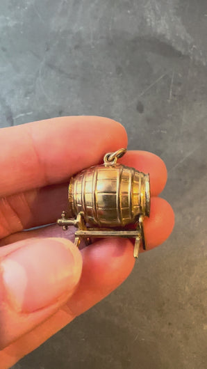 gold barrel charm held in hand