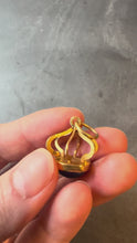 Load and play video in Gallery viewer, blue and gold pendant turned in hand on grey background
