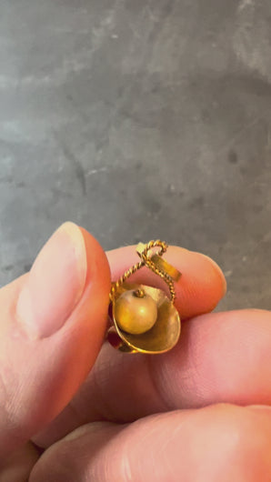 gold basket with white pearl turned in hand on grey background