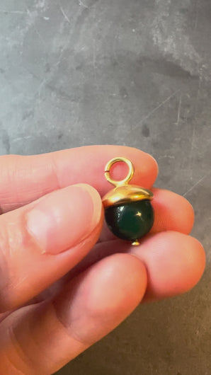 green and gold pendant held and turned in hand
