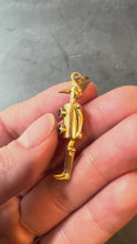 Load and play video in Gallery viewer, gold man pendant with red buttons turned in hand
