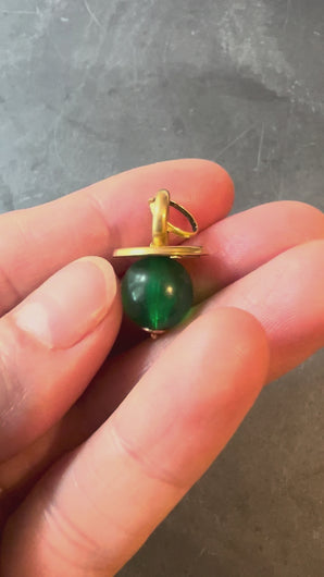 green. and gold pendant turned in hand