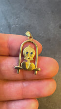 Load and play video in Gallery viewer, An 18 karat yellow gold charm pendant featuring a cartoon character bird on a perch with blue paste eyes turned in hand 
